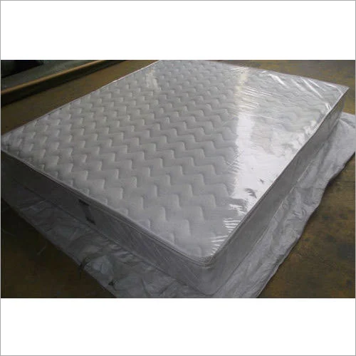White quilted mattress inside a transparent protective packaging cover